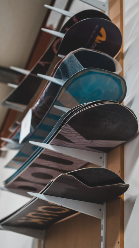 Many snowboards on a rack