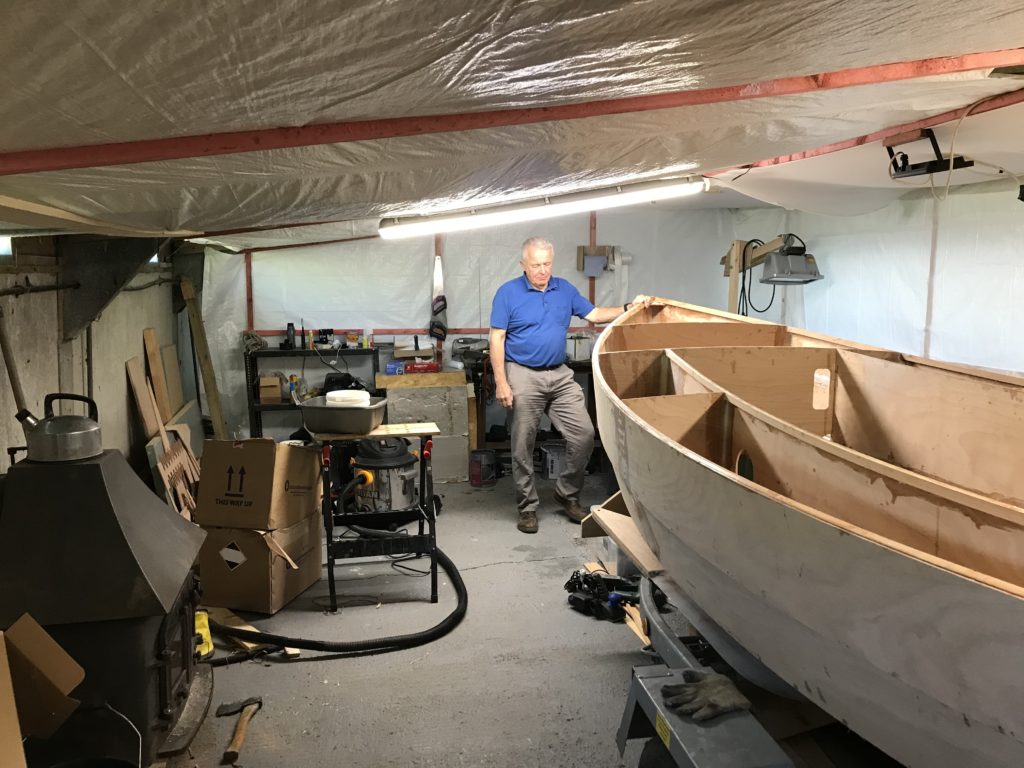 A man contemplating the next step stood in front of his boat held together with west system epoxy