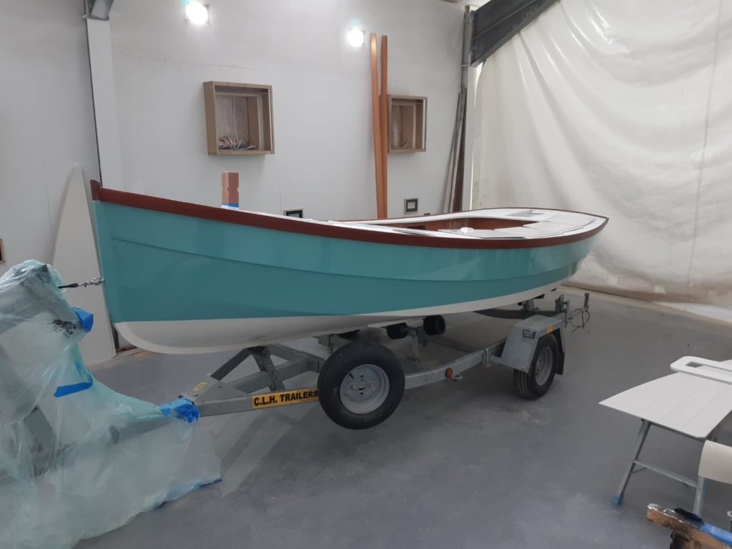 A transformed boat now covered in a light blue spray of paint by swallow yachts at their boatyard