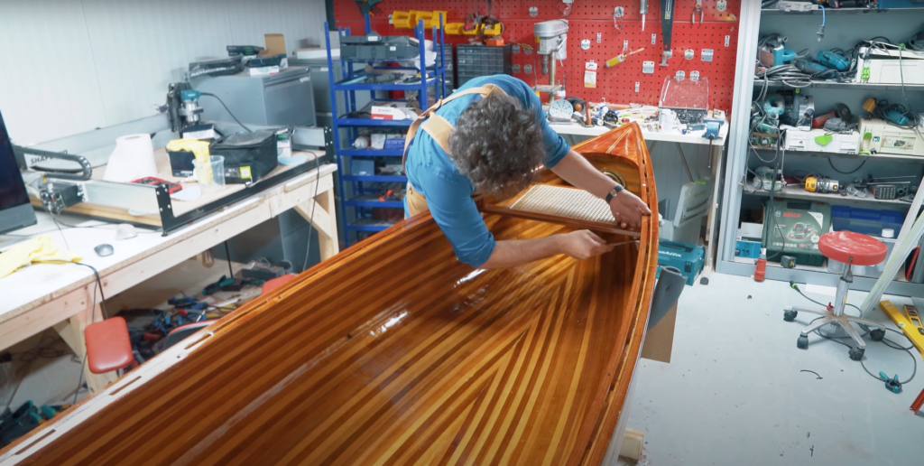 Sedar Bas in his workshop garage making his strip canoe built with west system epoxy