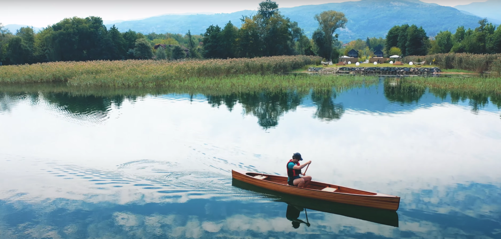 a man on the water in the canoe he built