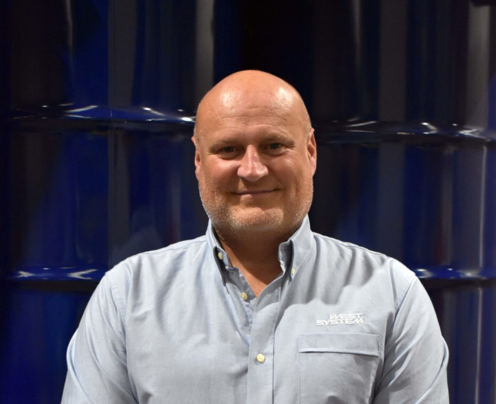 Headshot of Wessex Resins employee Martin Pickett in front of barrells
