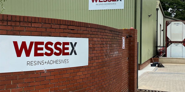 Wessex Resins factory exterior showing the logo on a brick wall