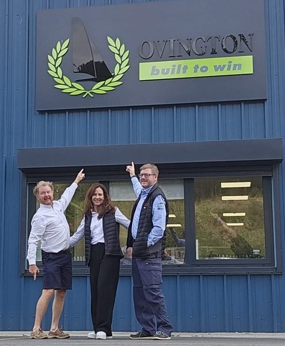 3 staff members in WRA uniform point to the Ovington building happily