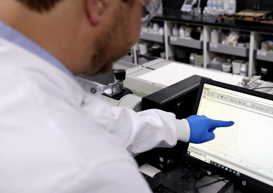 The Wessex Resins laboratory showing multiple counters and scientific machinery, a scientist points to a display