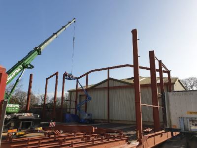 The wesesx resins factory expansion under construction, a crane positions metal beams