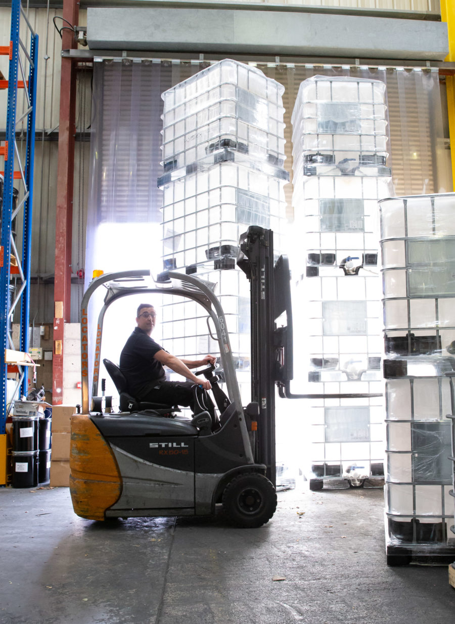 Wessex Resins employee operates forklift in warehouse, large containers can be seen all around