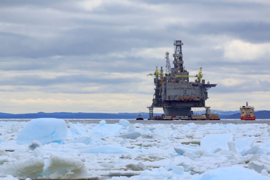 Offshore oil rig on the surface of icy water in the ocean.